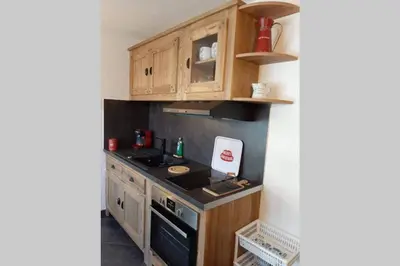 a kitchen with wooden cabinets and a stove at Chamonix centre - WIFI - Parking - Rés Aiguille du midi in Chamonix-Mont-Blanc