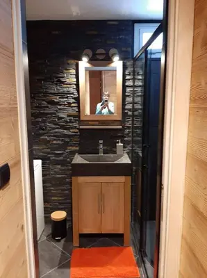 a man taking a picture of a bathroom with a sink at Chamonix centre - WIFI - Parking - Rés Aiguille du midi in Chamonix-Mont-Blanc