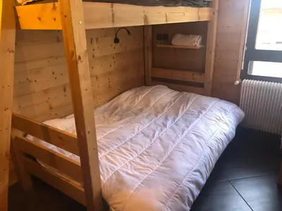 an empty bunk bed in a wooden room at Chamonix centre - WIFI - Parking - Rés Aiguille du midi in Chamonix-Mont-Blanc