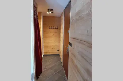 a hallway with a wooden wall in a bathroom at Chamonix centre - WIFI - Parking - Rés Aiguille du midi in Chamonix-Mont-Blanc