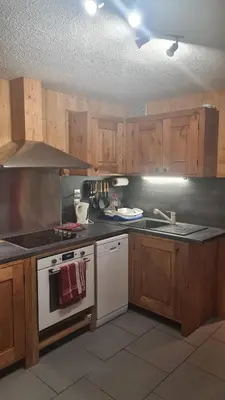 a kitchen with wooden cabinets and a white stove top oven at Chalet La Piste Bleu in Saint-Gervais-les-Bains