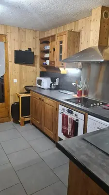 a kitchen with wooden cabinets and a stove top oven at Chalet La Piste Bleu in Saint-Gervais-les-Bains