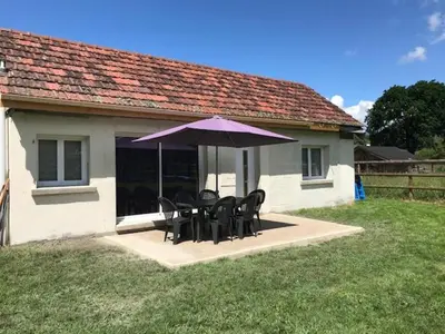 a table and chairs under a purple umbrella at maisonnette entre lac de Passy et montagnes in Domancy