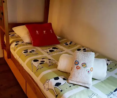a bed with a bedspread with cows on it at La Rivière Vue Mont Blanc in Chamonix-Mont-Blanc