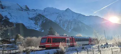 a red and white train traveling through a snow covered mountain at studio plein sud vue Mont Blanc CHAMONIX in Chamonix-Mont-Blanc