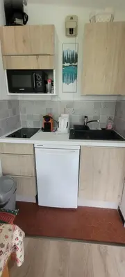 a small kitchen with a sink and a microwave at studio plein sud vue Mont Blanc CHAMONIX in Chamonix-Mont-Blanc