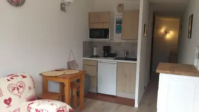 a small kitchen with a table and a chair at studio plein sud vue Mont Blanc CHAMONIX in Chamonix-Mont-Blanc