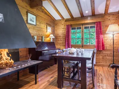 a dining room with a table and a piano at Chalet plein soleil 2 chambres à Megève, proche pistes - FR-1-453-255 in Megève