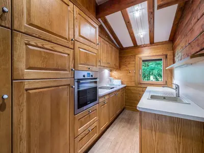 a kitchen with wooden cabinets and a sink and a stove at Chalet plein soleil 2 chambres à Megève, proche pistes - FR-1-453-255 in Megève