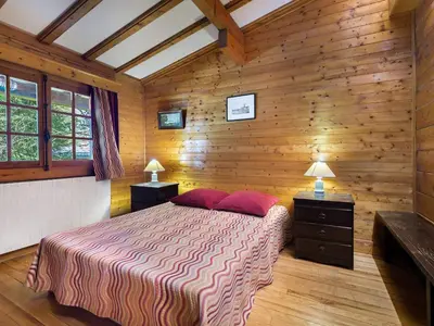 a bedroom with wooden walls and a bed with red pillows at Chalet plein soleil 2 chambres à Megève, proche pistes - FR-1-453-255 in Megève