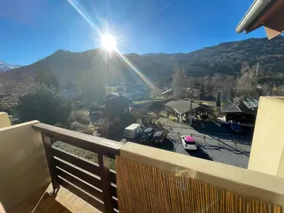 a balcony with the sun shining on a mountain at Studio « Au beau soleil » in Saint-Gervais-les-Bains