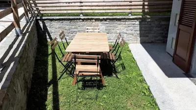 a wooden table and chairs sitting in the grass at Cham'Heart, 4-star apartments in Chamonix centre with free private parking in Chamonix-Mont-Blanc
