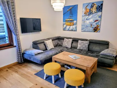 a living room with a couch and a table at Cham'Heart, 4-star apartments in Chamonix centre with free private parking in Chamonix-Mont-Blanc