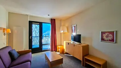 a living room with a couch and a tv and a window at Residence De La Foret - Appartement lumineux · Proche des pistes · Balcon MAE-5774 in Flaine