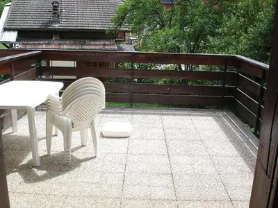 two white chairs and a table on a patio at Appartement idéal été ou hiver, pour skieurs et promeneurs, 4 personnes in Saint-Gervais-les-Bains