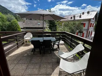 a table and chairs and an umbrella on a balcony at Appartement idéal été ou hiver, pour skieurs et promeneurs, 4 personnes in Saint-Gervais-les-Bains
