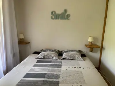 a bedroom with a bed with a smile sign on the wall at Les Frahans in Samoëns