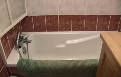 a bath tub in a bathroom with a green towel at Les Frahans in Samoëns