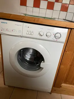 a washing machine in a kitchen under a counter at Les Frahans in Samoëns
