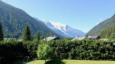 a view of a mountain range with houses and trees at studio residence Grands Montets in Chamonix-Mont-Blanc