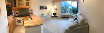 a living room with a couch and a kitchen at studio residence Grands Montets in Chamonix-Mont-Blanc