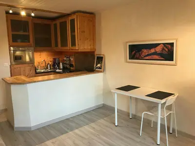 a small kitchen with a counter and a table at studio residence Grands Montets in Chamonix-Mont-Blanc