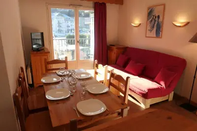 a living room with a table and a red couch at Le Grand Panorama in Saint-Gervais-les-Bains