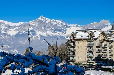a building with a snow covered mountain in the background at Le Grand Panorama in Saint-Gervais-les-Bains