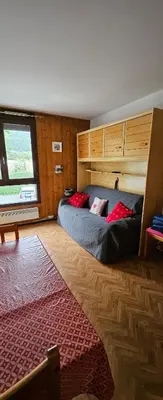 a bedroom with a bed with red pillows on it at Studio pieds des pistes les Houches Vallée de Chamonix in Les Houches