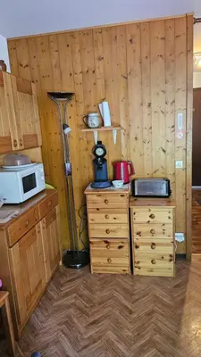 a kitchen with wooden walls and a microwave on a counter at Studio pieds des pistes les Houches Vallée de Chamonix in Les Houches