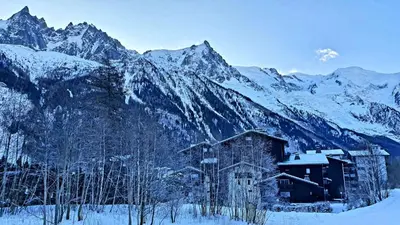 a building in front of a snow covered mountain at Cosy studio on the slopes and centre of Chamonix in Chamonix-Mont-Blanc