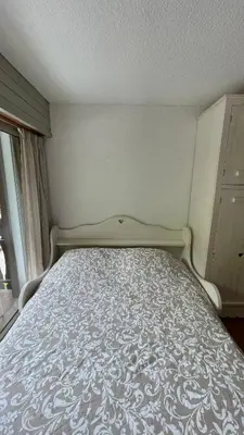 a bed in a small room with a bed frame at Cosy studio on the slopes and centre of Chamonix in Chamonix-Mont-Blanc