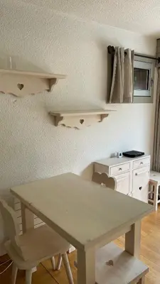 a table and chairs in a room with a kitchen at Cosy studio on the slopes and centre of Chamonix in Chamonix-Mont-Blanc