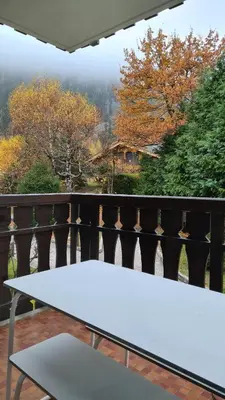 a white table sitting on a balcony with a view at Cosy studio on the slopes and centre of Chamonix in Chamonix-Mont-Blanc