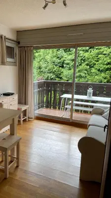 a living room with a large window and a balcony at Cosy studio on the slopes and centre of Chamonix in Chamonix-Mont-Blanc