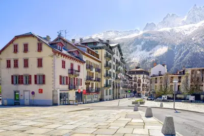 a city street with buildings and mountains in the background at Appartement du Mont - Résidence La Vardaffe - Welkeys in Chamonix-Mont-Blanc