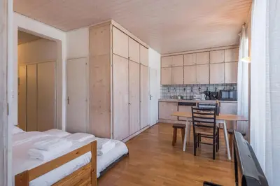 a room with a bed and a kitchen with a table at Appartement du Mont - Résidence La Vardaffe - Welkeys in Chamonix-Mont-Blanc
