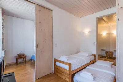 a bedroom with two beds and a mirror at Appartement du Mont - Résidence La Vardaffe - Welkeys in Chamonix-Mont-Blanc