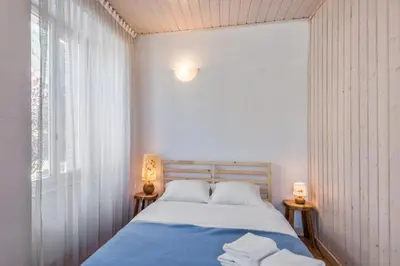 a bedroom with a bed with blue sheets and a window at Appartement du Mont - Résidence La Vardaffe - Welkeys in Chamonix-Mont-Blanc