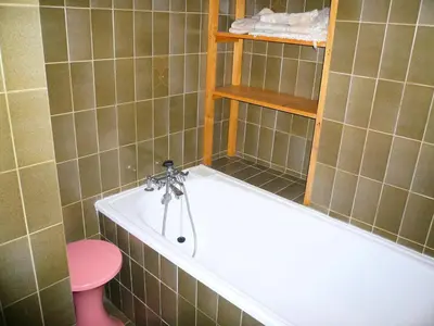 a bathroom with a bath tub and a pink stool at Résidence Les Cristaux Du Haut - Cristaux 51 MAE-5310 in Combloux