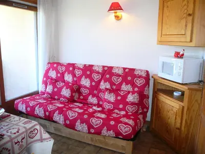 a red couch in a room with a microwave at Résidence Perle Des Neiges - Perles des Neiges 1 MAE-5319 in Combloux