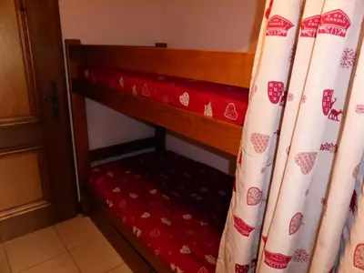 a room with a bed with curtains next to a door at Résidence Gros Cailloux Amethyste - Gros Cailloux A7 MAE-5328 in Combloux