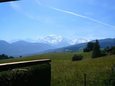 a bench in a field with mountains in the background at Résidence Gros Cailloux Amethyste - Gros Cailloux A7 MAE-5328 in Combloux