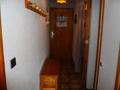 a hallway with a wooden table and a door at Résidence Les OrÉades - Oréades B04 MAE-5329 in Combloux