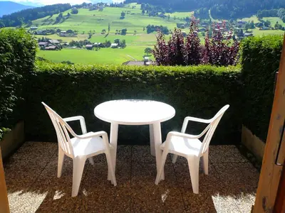 a white table and chairs with a view of a field at Résidence Les OrÉades - Oréades B04 MAE-5329 in Combloux