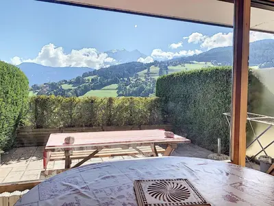 a table and a bench on a patio with a view at Charmant studio près du centre de Combloux avec kitchenette - FR-1-560-54 in Combloux