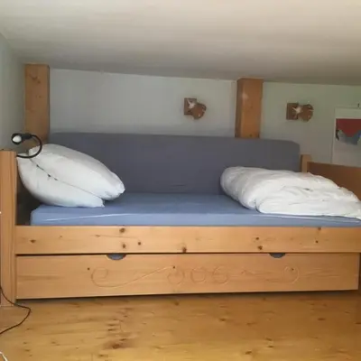 a bed with two pillows on it in a room at Appartement typique,chaleureux et pratique in Chamonix-Mont-Blanc