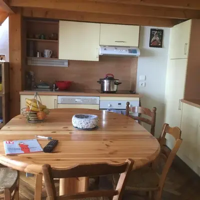 a kitchen with a wooden table and a kitchen with a stove at Appartement typique,chaleureux et pratique in Chamonix-Mont-Blanc