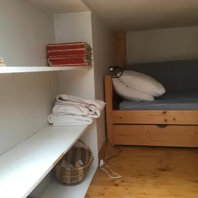 a small room with a bed and a shelf at Appartement typique,chaleureux et pratique in Chamonix-Mont-Blanc