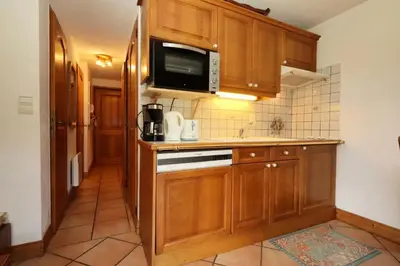 a kitchen with wooden cabinets and a microwave at Résidence Les Hauts De Chavants - Hauts de Chavants Bellachat 1 MAE-7730 in Les Houches
